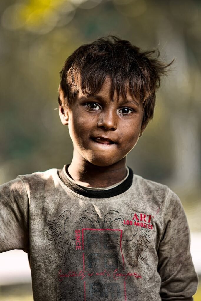 Close-up portrait of a young South Asian boy with a thoughtful expression, outdoors in Noida, India.