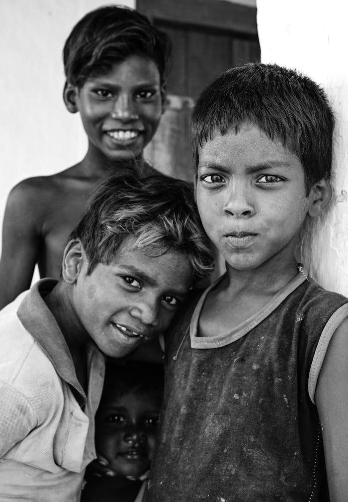 Captivating black and white portrait of smiling Indian children outdoors.